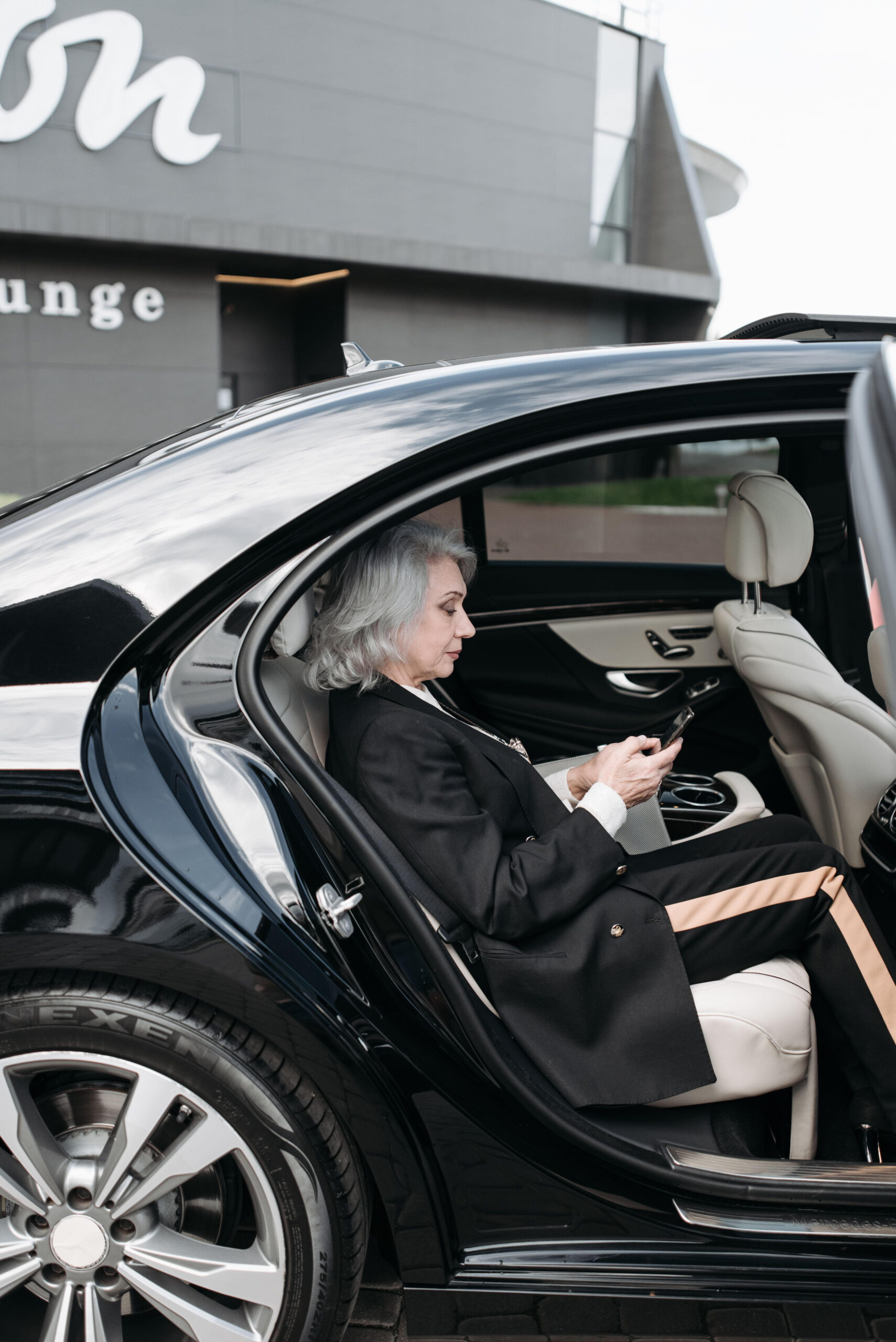 Executive utilising vehicle interior for work during professional chauffeur service in London