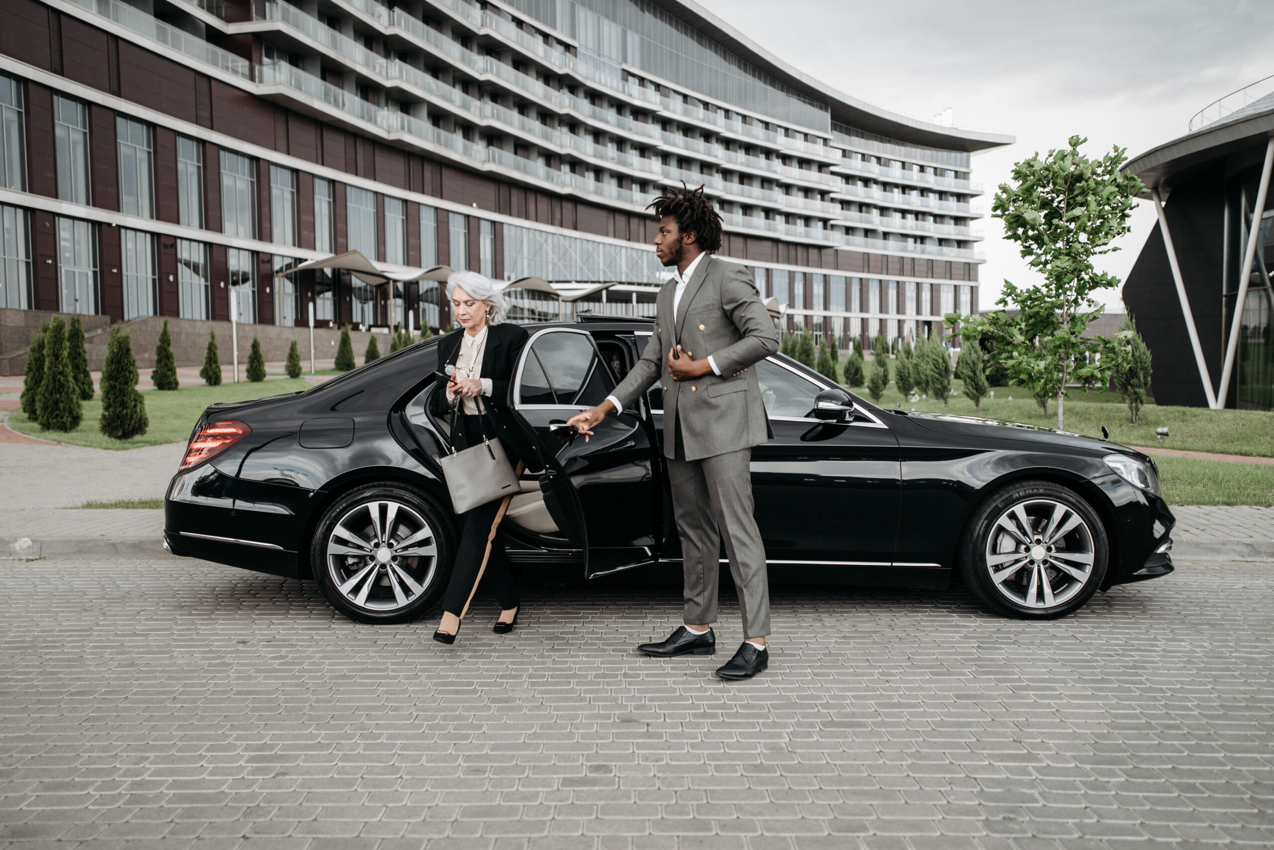 Professional chauffeur assisting a corporate client, emphasising luxury transport solutions in London