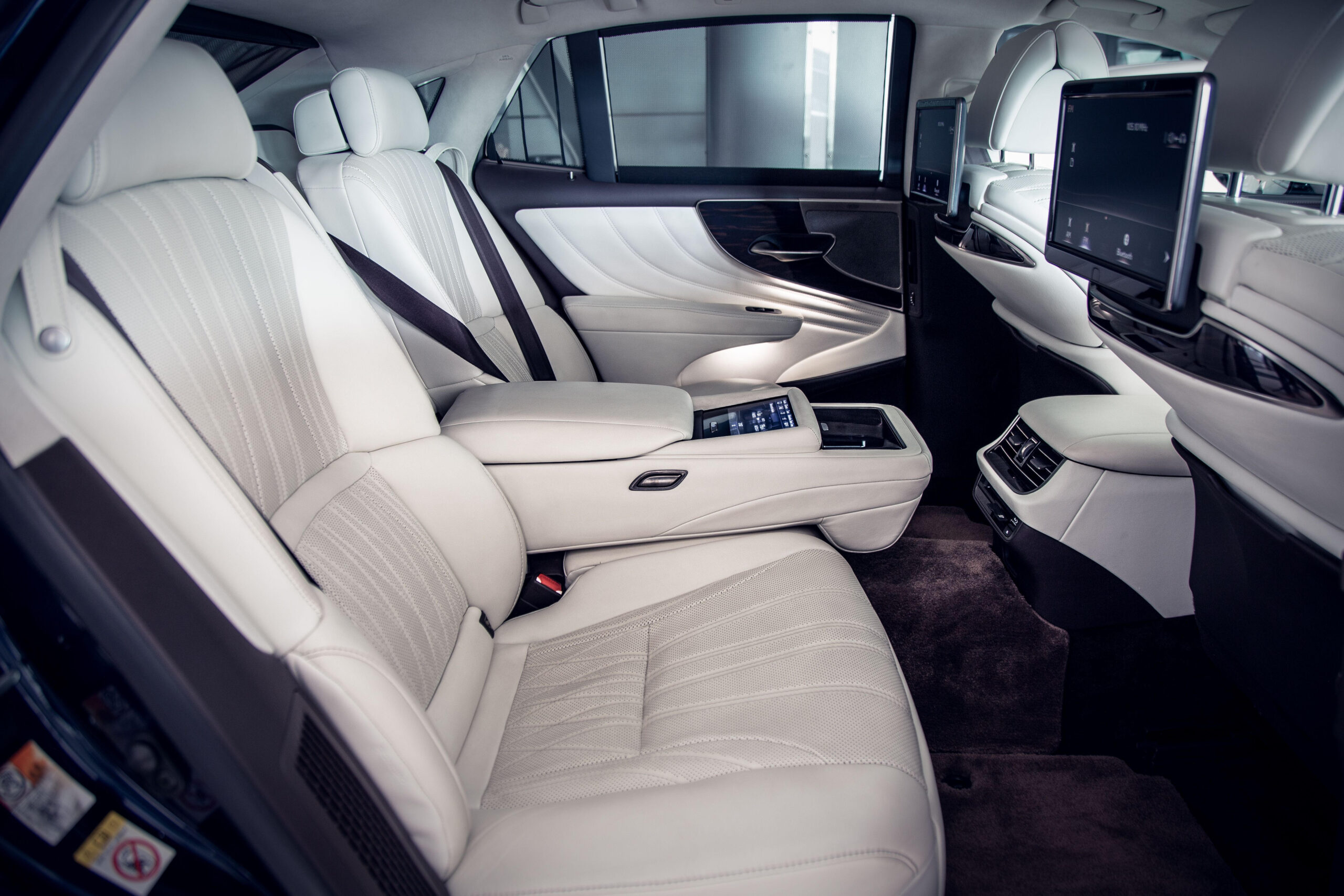 Interior of luxury vehicle showcasing onboard amenities like refreshments and Wi-Fi, enhancing travel experience